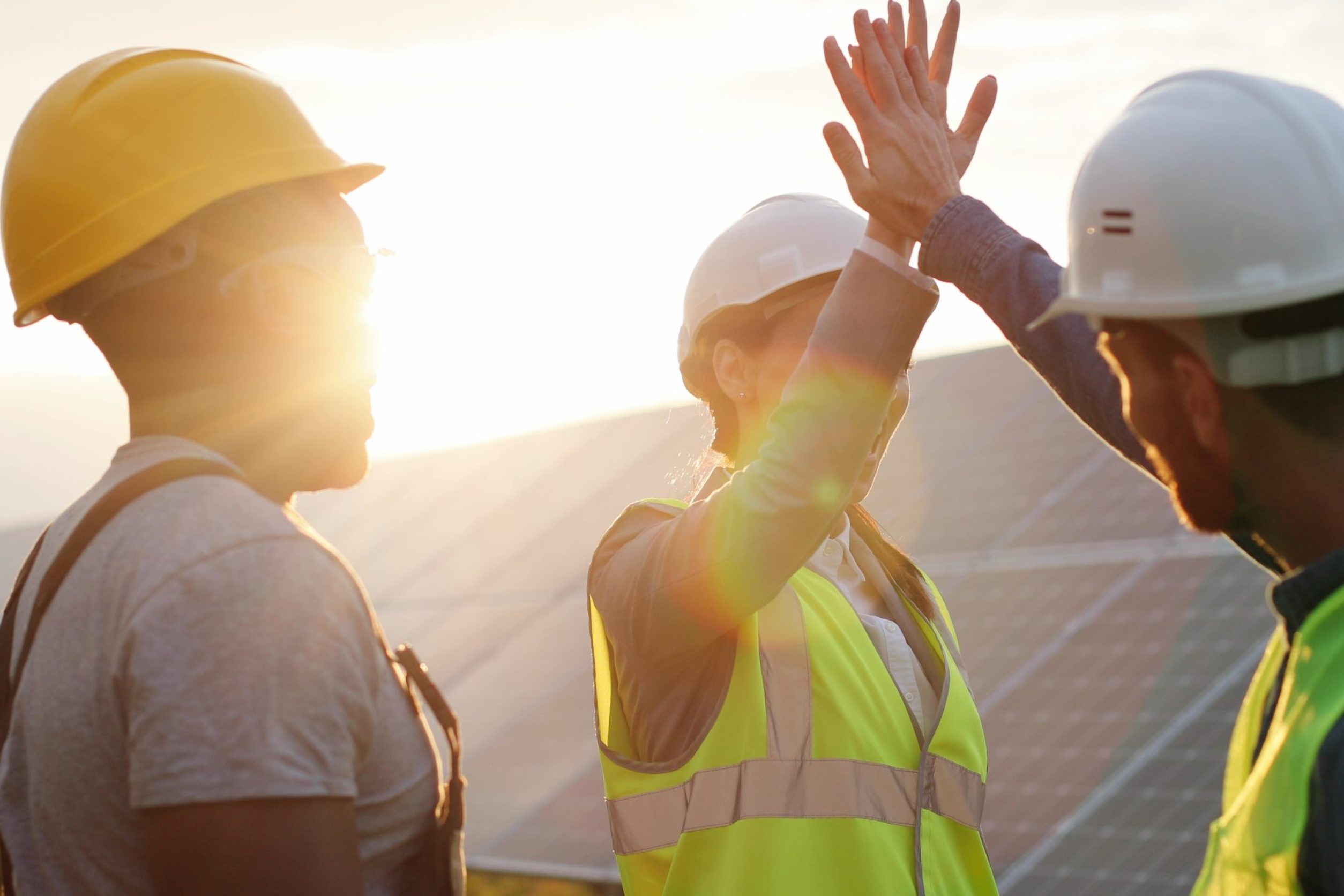 Happy,Employees,Of,Solar,Power,Plant,Raise,Their,Hands,And